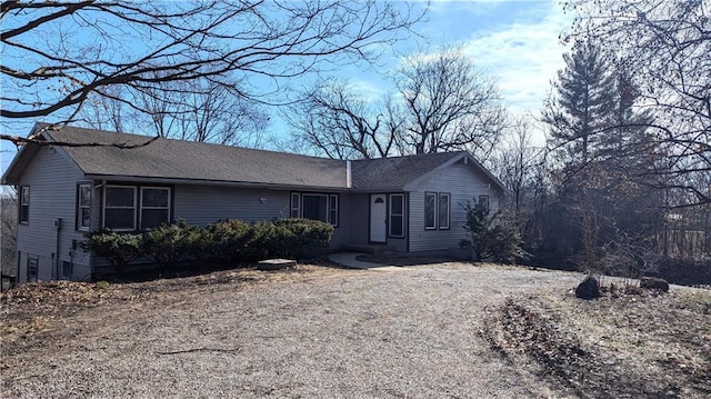 single story home with dirt driveway