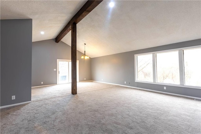 spare room featuring vaulted ceiling with beams, carpet floors, a textured ceiling, and baseboards