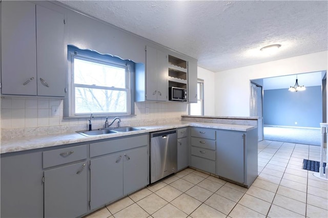 kitchen with gray cabinets, stainless steel dishwasher, light tile patterned flooring, a sink, and a peninsula