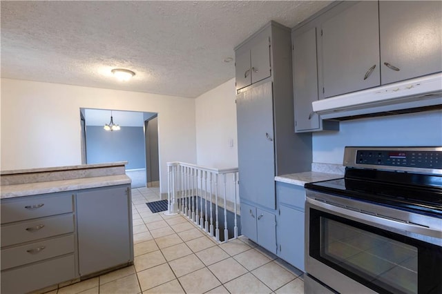 kitchen featuring gray cabinetry, light countertops, stainless steel range with electric stovetop, and under cabinet range hood