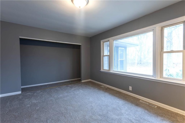 carpeted empty room with a healthy amount of sunlight and baseboards