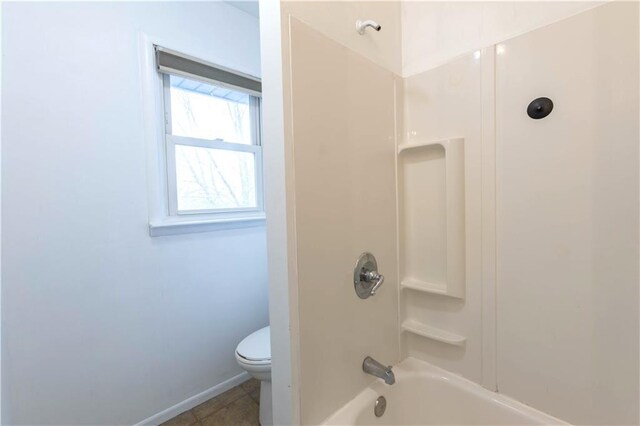 full bathroom with toilet, tile patterned flooring, washtub / shower combination, and baseboards