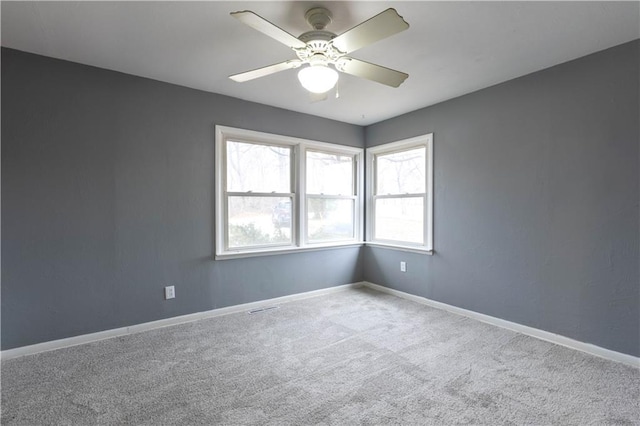 spare room featuring visible vents, carpet, a ceiling fan, and baseboards