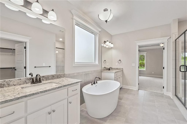 bathroom with two vanities, a sink, a shower stall, and tile patterned floors