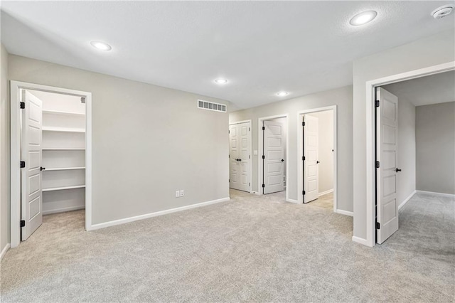 unfurnished bedroom with baseboards, visible vents, and light colored carpet