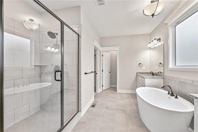 7005 NE 102nd Ct, Kansas City, MO 64156 - full bath featuring a soaking tub, vanity, a stall shower, and tile patterned flooring