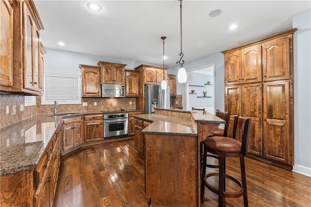 kitchen with tasteful backsplash, a center island, dark wood-type flooring, stainless steel appliances, and a sink