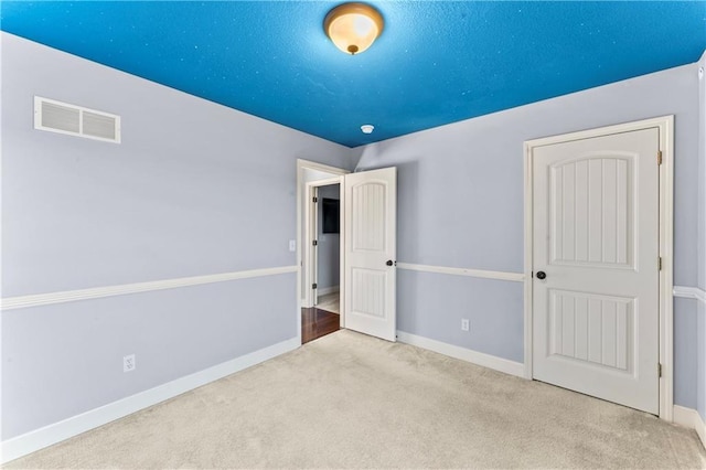 unfurnished bedroom with baseboards, visible vents, and carpet floors