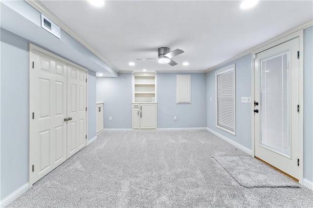 below grade area featuring visible vents, baseboards, carpet, and a ceiling fan