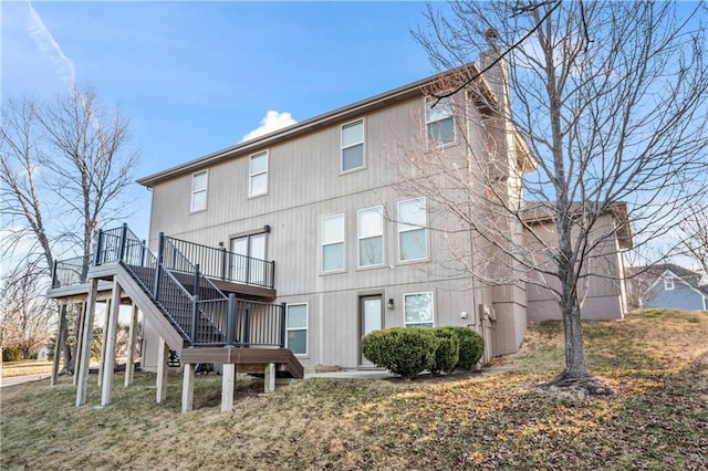 rear view of house with stairs and a deck