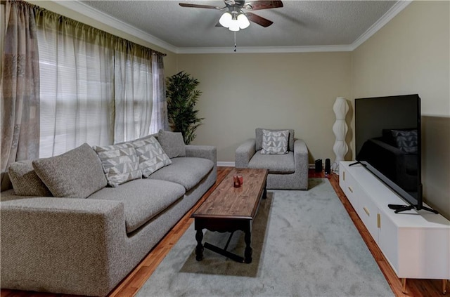 living area with a ceiling fan, a textured ceiling, ornamental molding, and wood finished floors