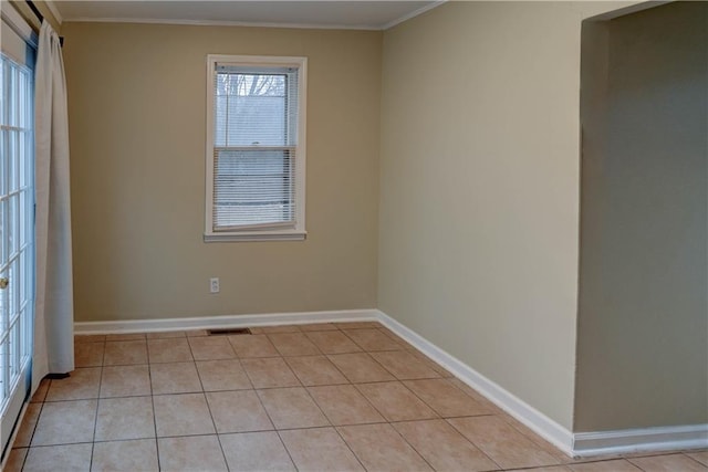 unfurnished room featuring light tile patterned floors, ornamental molding, plenty of natural light, and visible vents