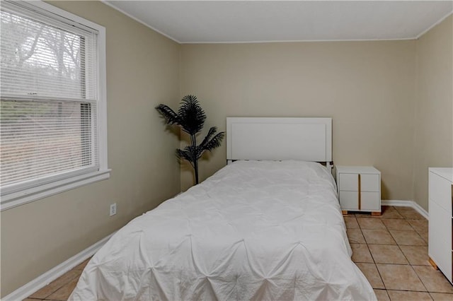 bedroom featuring light tile patterned floors and baseboards