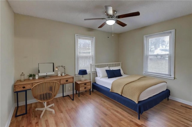 bedroom featuring light wood-style floors, baseboards, and a ceiling fan