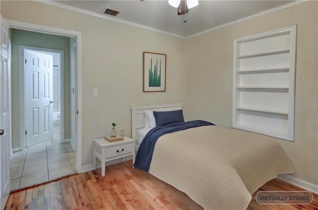 bedroom with ornamental molding, light wood-type flooring, visible vents, and baseboards