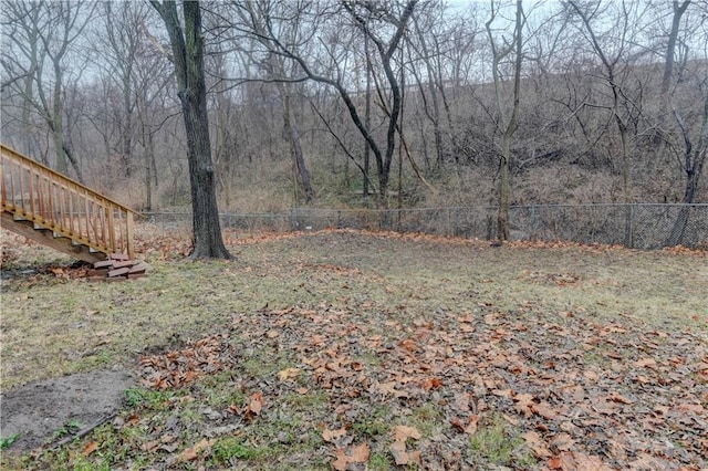 view of yard with a forest view and fence