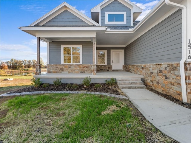 entrance to property with stone siding and a porch