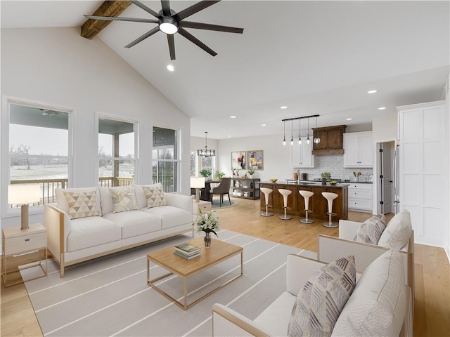 living room featuring beam ceiling, plenty of natural light, recessed lighting, and light wood-type flooring