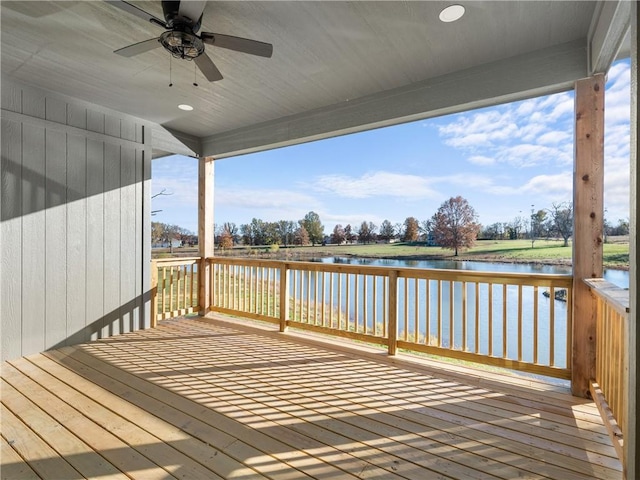 deck with a water view and ceiling fan