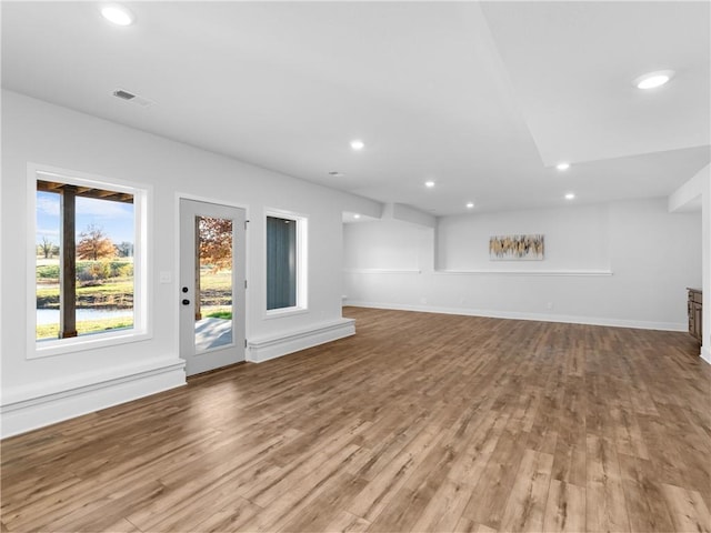 unfurnished living room with recessed lighting, baseboards, and wood finished floors