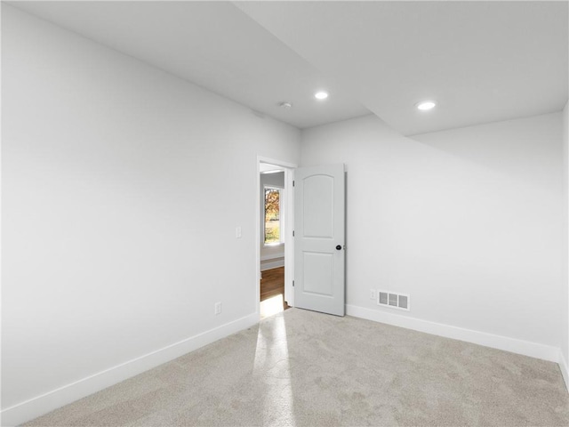 carpeted spare room featuring recessed lighting, baseboards, and visible vents