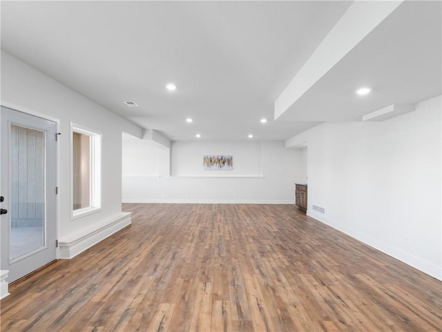 unfurnished living room with recessed lighting, visible vents, baseboards, and wood finished floors