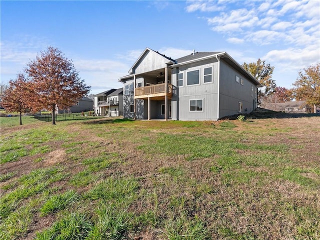 rear view of property featuring a lawn, ceiling fan, and fence