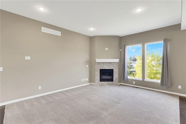 unfurnished living room with a tile fireplace, visible vents, baseboards, and recessed lighting