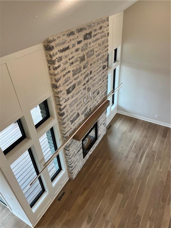 unfurnished living room featuring visible vents, baseboards, and wood finished floors