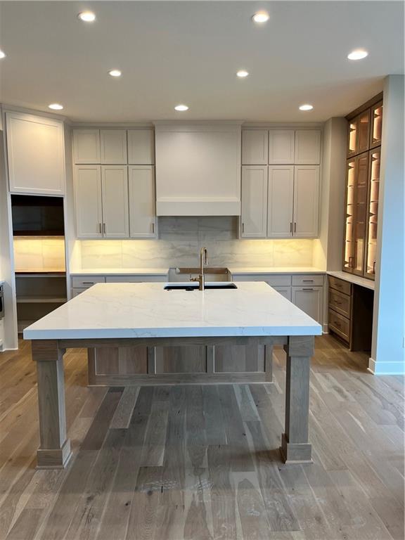 kitchen featuring decorative backsplash, recessed lighting, and a sink