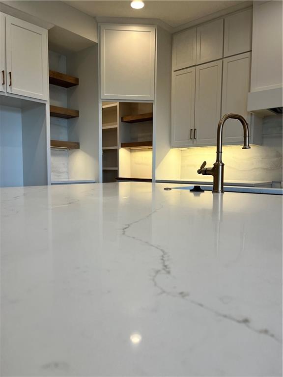 kitchen with open shelves and light stone countertops