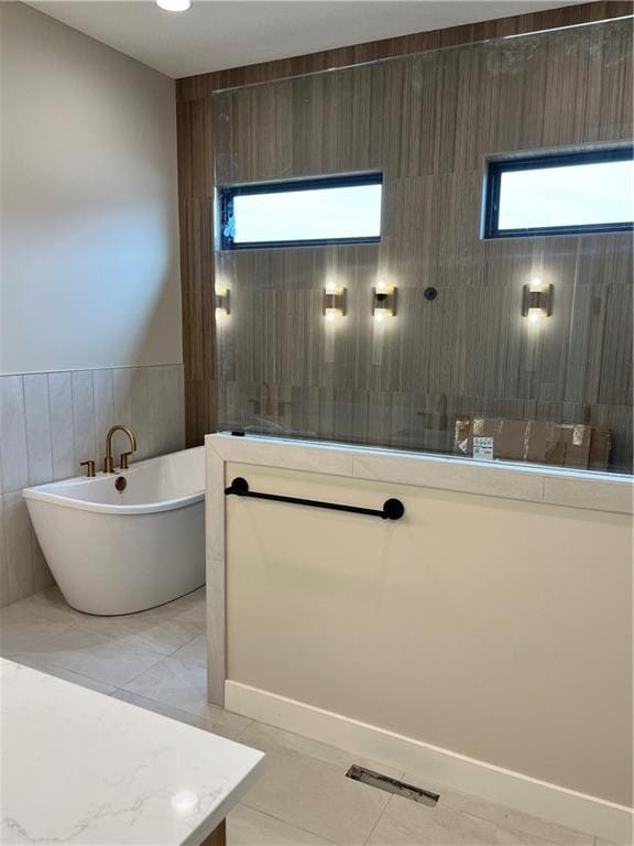 bathroom featuring tile patterned floors, a walk in shower, visible vents, and a freestanding bath