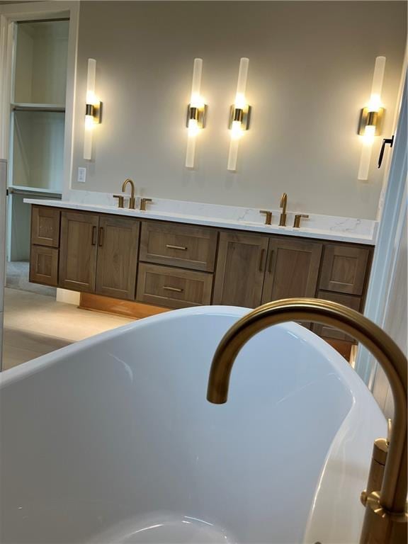 full bath featuring a soaking tub and a sink