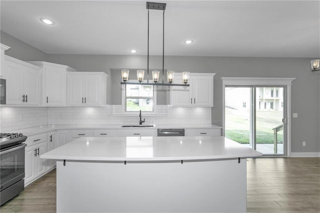 kitchen featuring a center island, gas range oven, backsplash, a sink, and dishwasher