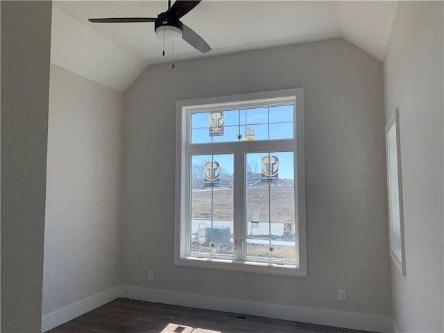 unfurnished room featuring vaulted ceiling, dark wood-style floors, baseboards, and visible vents