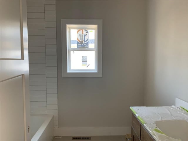 bathroom featuring visible vents, a bathtub, and vanity