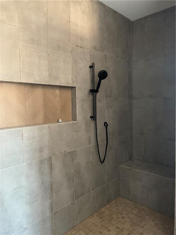 full bathroom featuring tiled shower