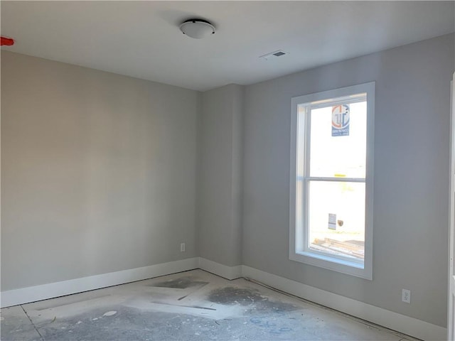 unfurnished room with visible vents and baseboards