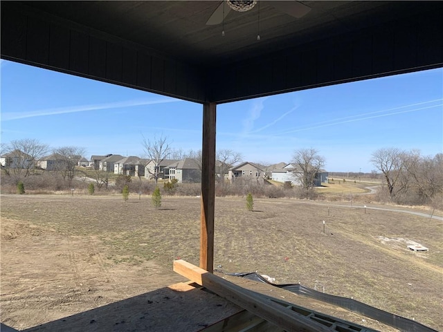 view of yard featuring a residential view and ceiling fan