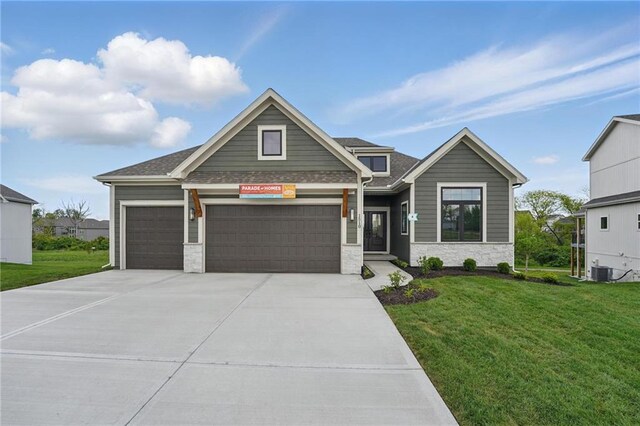 1510 NW 106th Ter, Kansas City, MO 64155 - craftsman-style home featuring a front yard, driveway, an attached garage, and stone siding