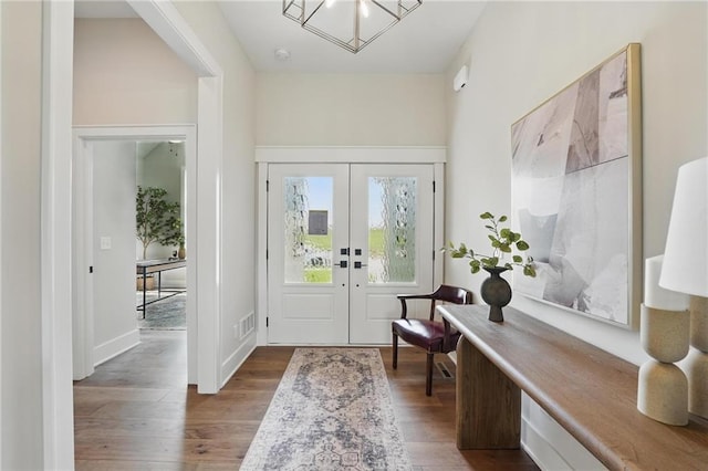 1510 NW 106th Ter, Kansas City, MO 64155 - foyer entrance with an inviting chandelier, wood finished floors, visible vents, and french doors