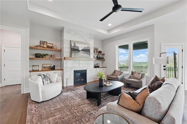1510 NW 106th Ter, Kansas City, MO 64155 - living room featuring ceiling fan, a fireplace, wood finished floors, a raised ceiling, and recessed lighting