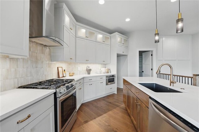 1510 NW 106th Ter, Kansas City, MO 64155 - kitchen featuring appliances with stainless steel finishes, a sink, light countertops, wall chimney exhaust hood, and dark wood-style floors
