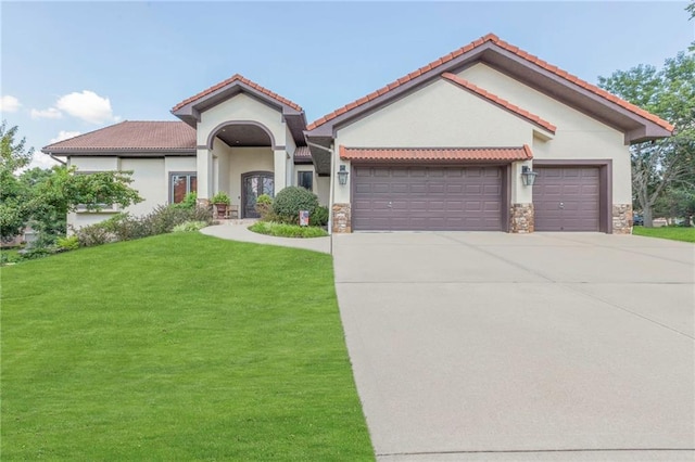 mediterranean / spanish home featuring stucco siding, concrete driveway, a front lawn, and a garage