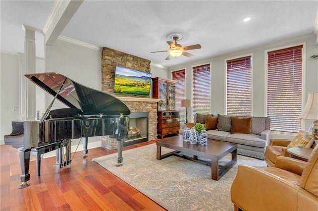 living area with a fireplace, wood finished floors, and ornamental molding