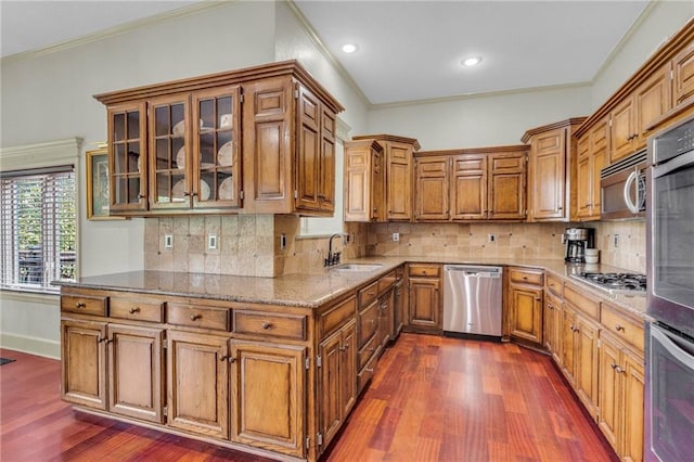 kitchen featuring a sink, light stone countertops, brown cabinets, and stainless steel appliances