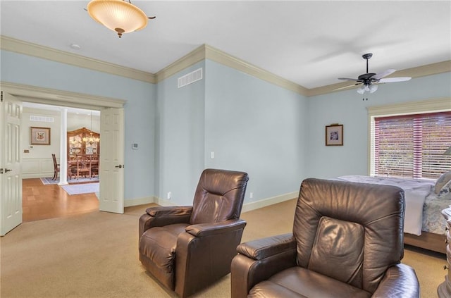 sitting room featuring a ceiling fan, baseboards, light colored carpet, and crown molding