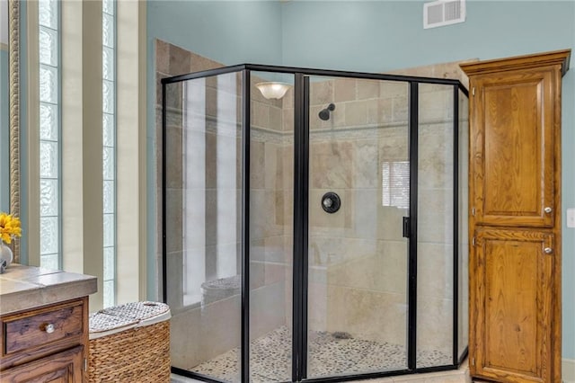 bathroom featuring vanity, a shower stall, and visible vents