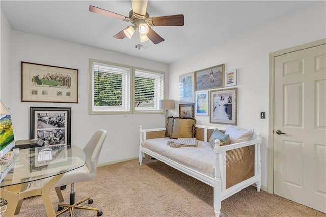 carpeted office space with baseboards and a ceiling fan