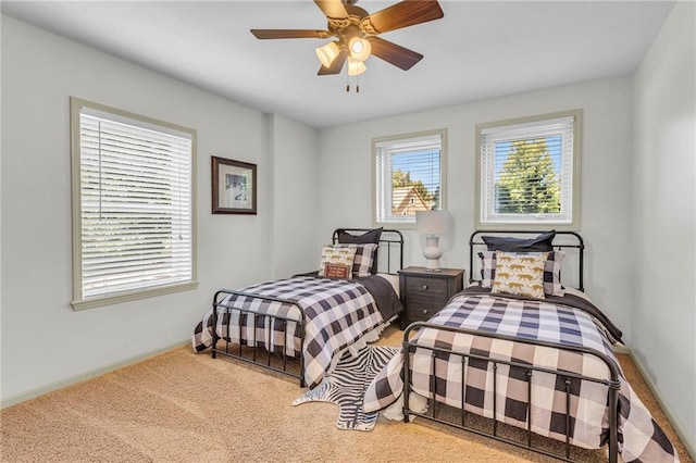 carpeted bedroom with baseboards and a ceiling fan